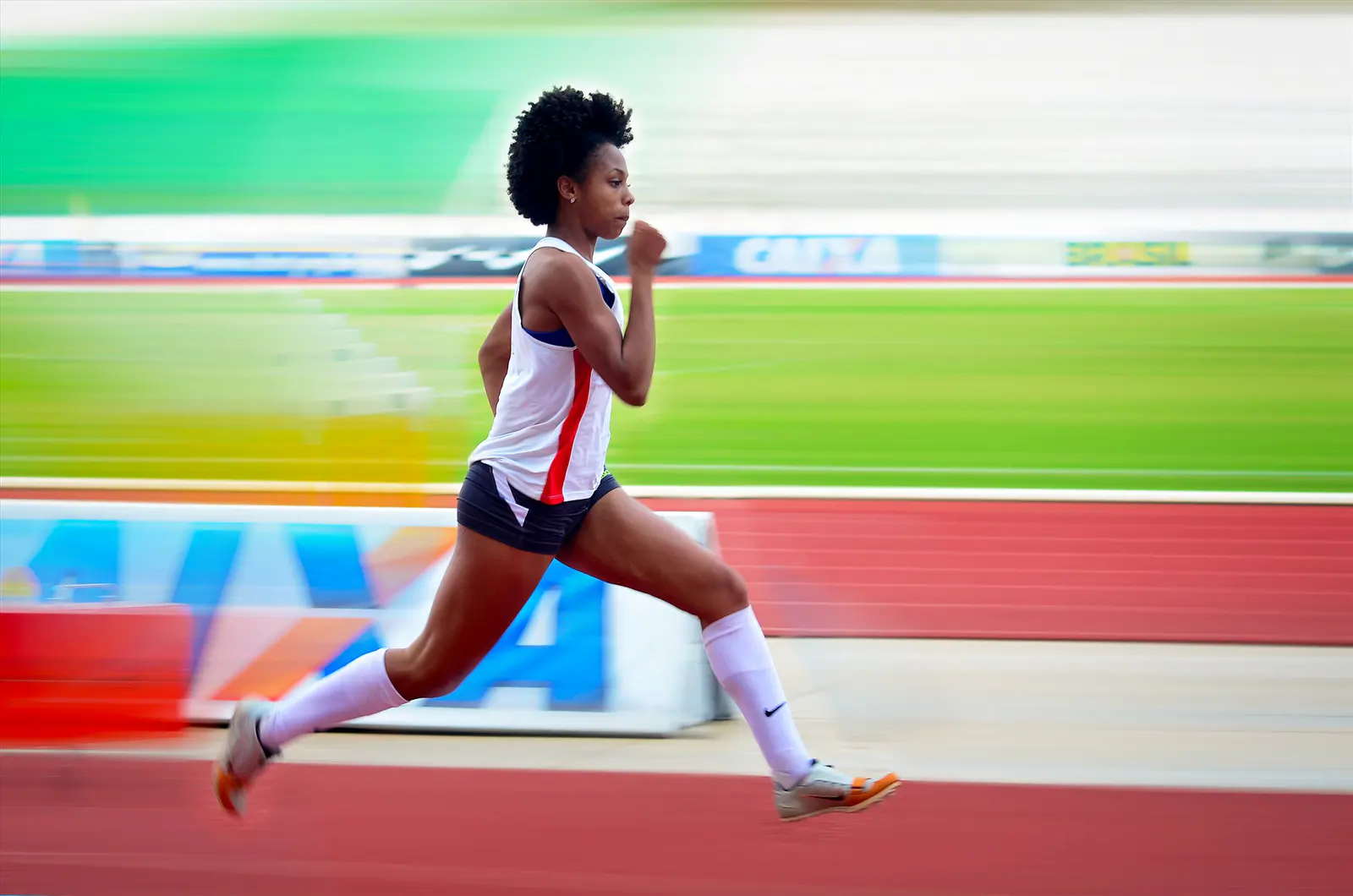 Atleta correndo em pista com fundo em movimento